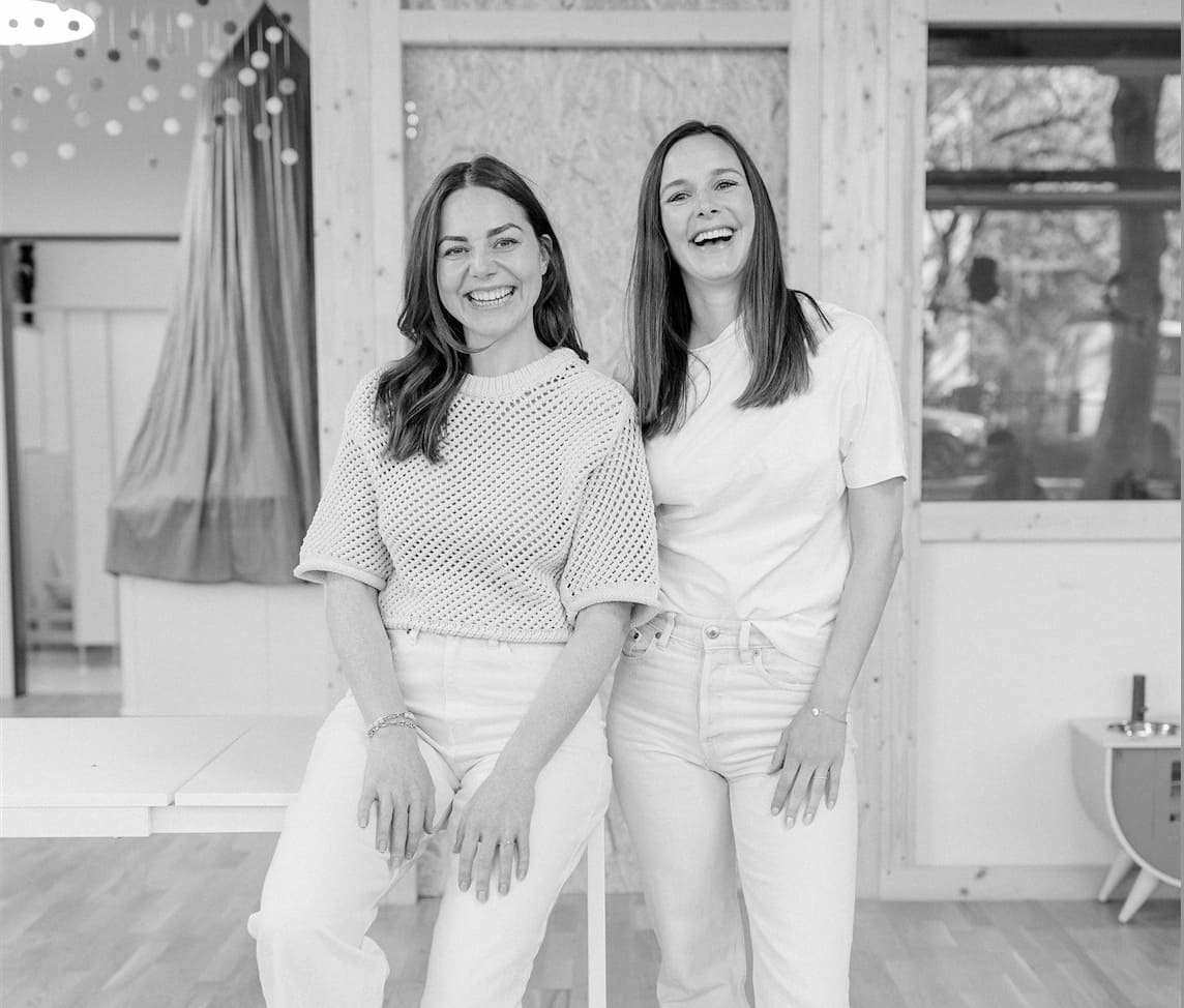 Two laughing woman: Belén Bolliger and Anna Mucha-  founders of OiOiOi, black white